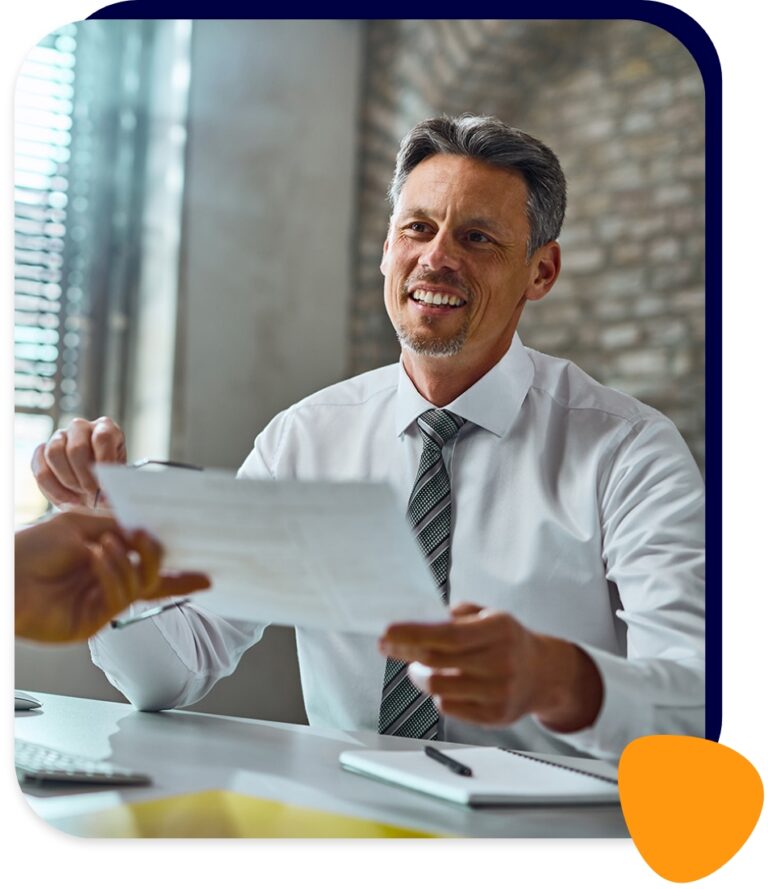 Un consultant RH remettant un document à un chef d'entreprise